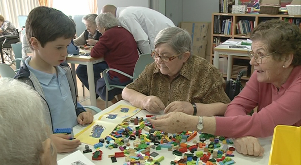 Padrins i nens comparteixen una activitat intergeneracional al voltant de les peces de Lego